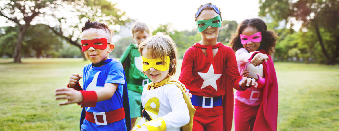 Kids dressed as superheros playing in field