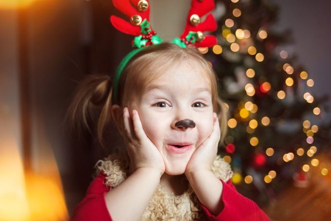 Little girl dressing up as reindeer for Christmas