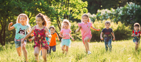 happy children running in field in summer