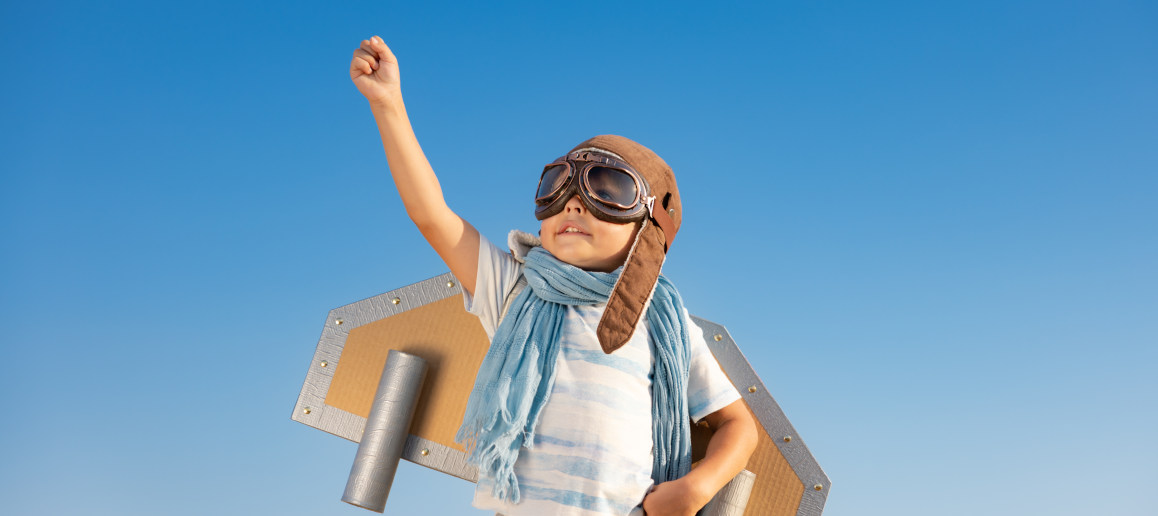 Happy young boy dressing up with rocket wings