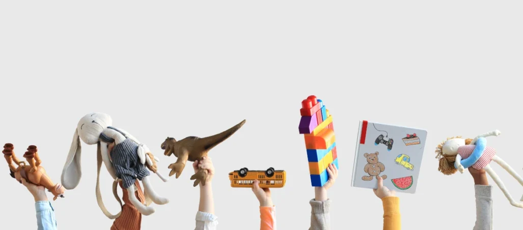 children's hands holding toys in the air