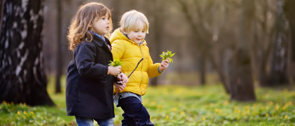 Young boy and girl playing outside in spring