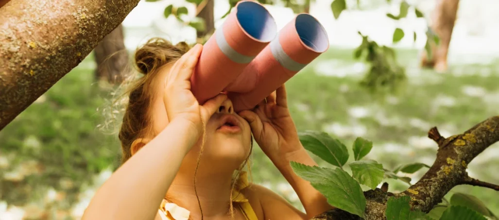 young girl looking through binoculars