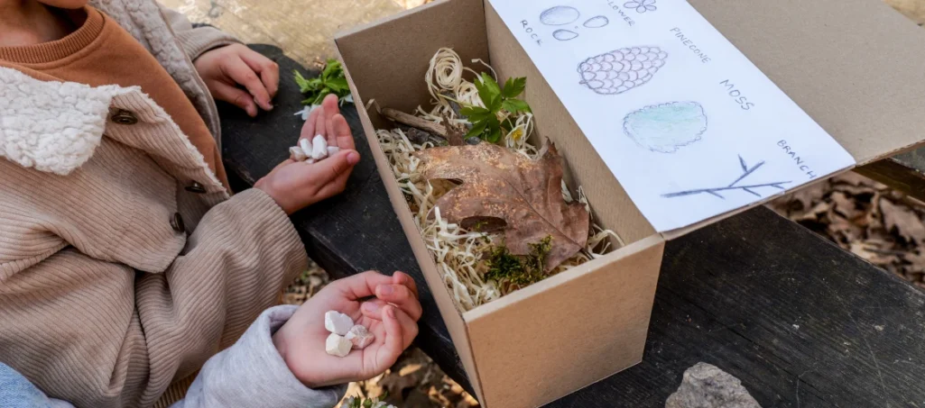 Young children exploring content of a nature box